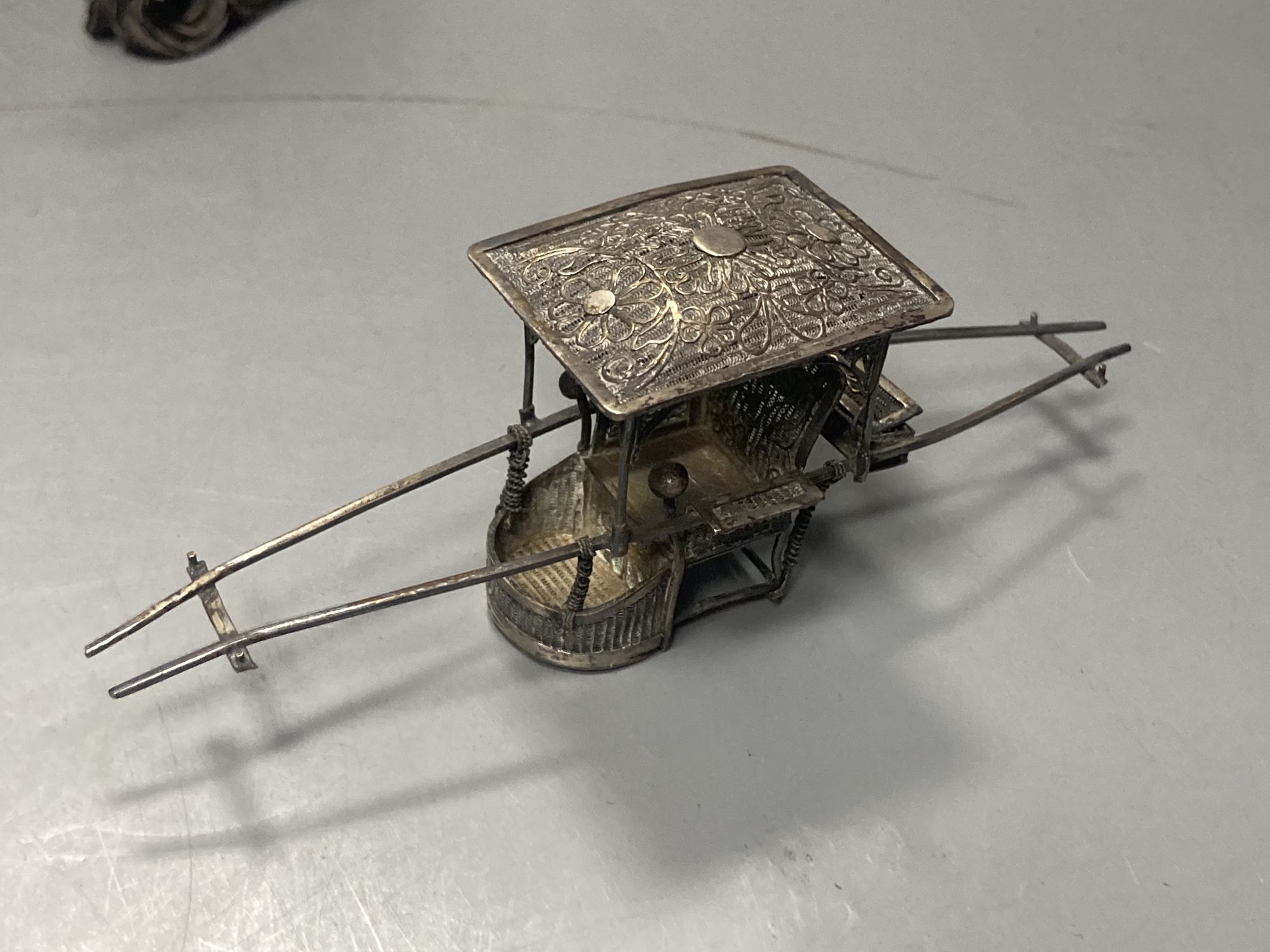 A group of Chinese white metal models of a sampan by Wang Hing, rickshaw and sedan chair etc.